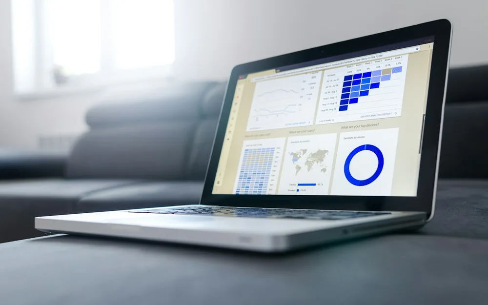 A laptop displaying charts and a data dashboard.